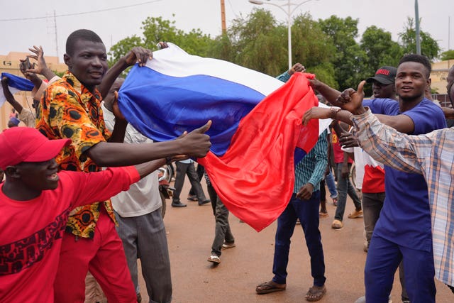 78e37f5aa5b640229d90e95f25b1f385-1 Supporters of mutinous soldiers hold a Russian flag as they demonstrate in Niamey, Niger