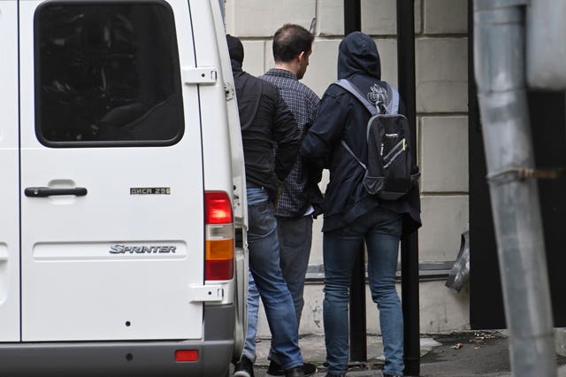 Wall Street Journal reporter Evan Gershkovich, centre back to the camera, is escorted to the Lefortovsky court in Moscow, Russia
