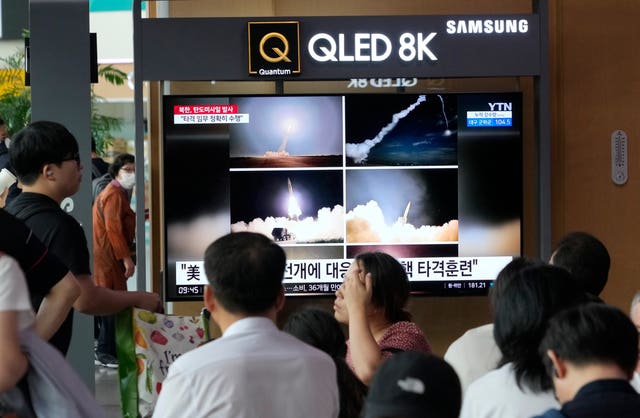 d31129c03ebc410d99000f19b7bf7b34 TV screen in train station showing missile launch images