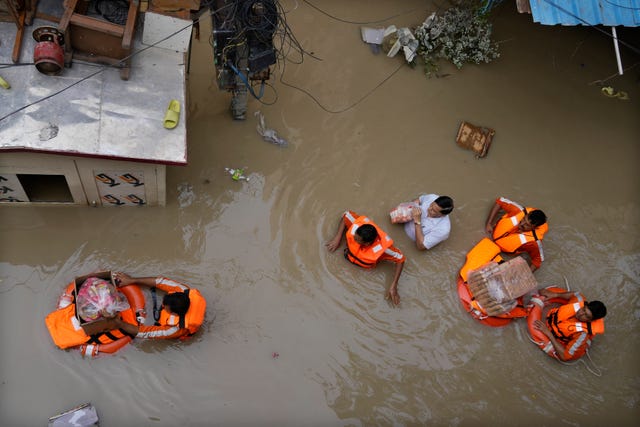 e33407b17a824f9382b1d33fc68d17a9 Rescue workers in flood waters