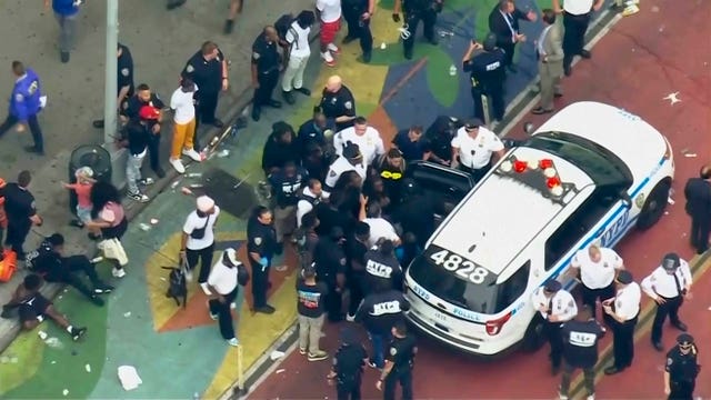 ecf529cbed914264913c69f6ea4e5172 Crowd of people around a police car