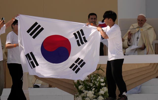 South Korean pilgrims hold their national flag