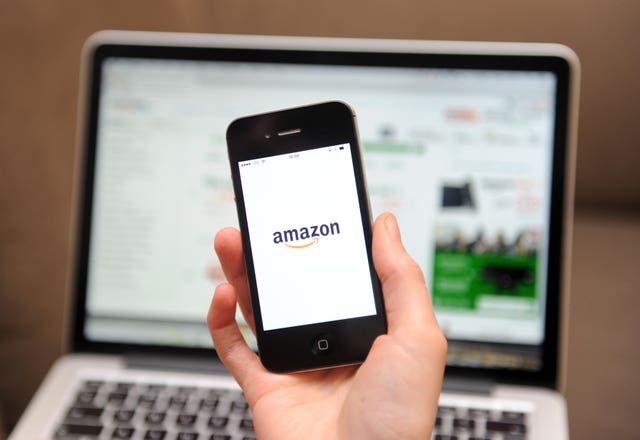 2-21617212 A woman uses a smartphone to browse the Amazon website