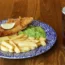 A plate of fish and chips alongside a pint of beer