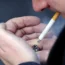 A man lighting up a cigarette