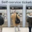 Passengers using ticket machines at a railway station