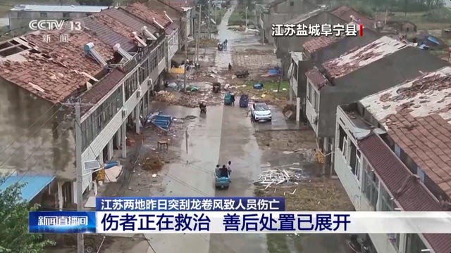 People walk past damaged houses in the aftermath of the tornado