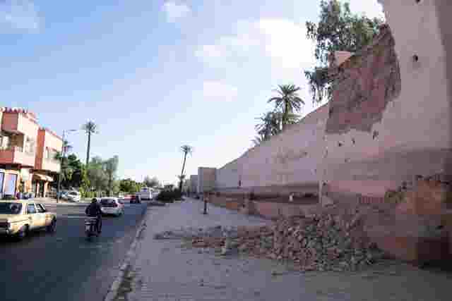 9ca08fdd29e9410ea690ac0d1be7e9f2 People drive past a damaged wall of the historic Medina of Marrakesh