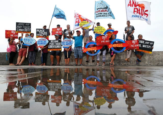 Protesters display placards and shout slogans in a protest against China over its coastguards’ alleged seizure of fish caught by Filipino fishermen near the contested Scarborough Shoal in 2018