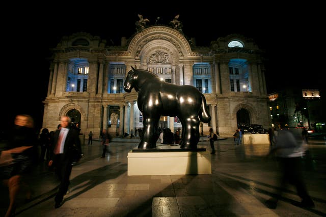 c76cc335fb1749f586c2281fde69a5a3 A statue by Botero stands outside the Fine Arts Palace during the inauguration of Botero’s retrospective exhibit titled “Fernando Botero: a celebration” in Mexico City, March 29, 2012