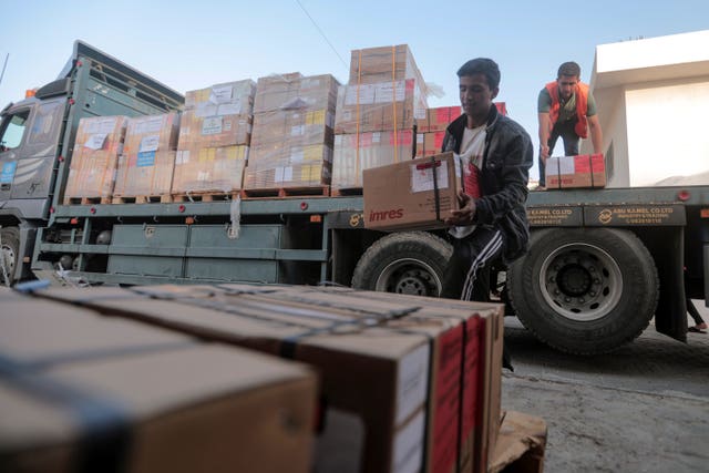 49fa2aac8cfe42a2a981a383053fabd1-1 Palestinians unload boxes of medicine from a truck