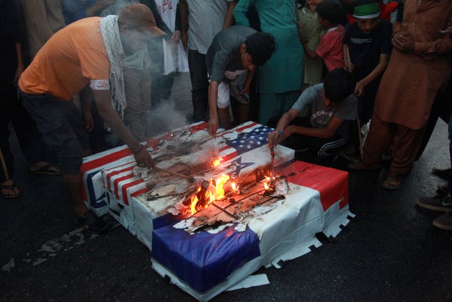 57269a39371d4f15972cc6ca4dcc2f5f Supporters burn representations of Israeli, US, English and French flags, during a protest against Israeli airstrikes on Gaza, in Karachi, Pakistan