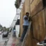 Employees cover the windows of a store with wood in preparation for the arrival of Hurricane Norma,