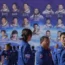 Chinese Manned Space Agency staff gather near a billboard depicting astronauts from past Shenzhou missions
