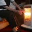 Elderly woman in front of heater
