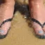 Feet in flip flops on a beach