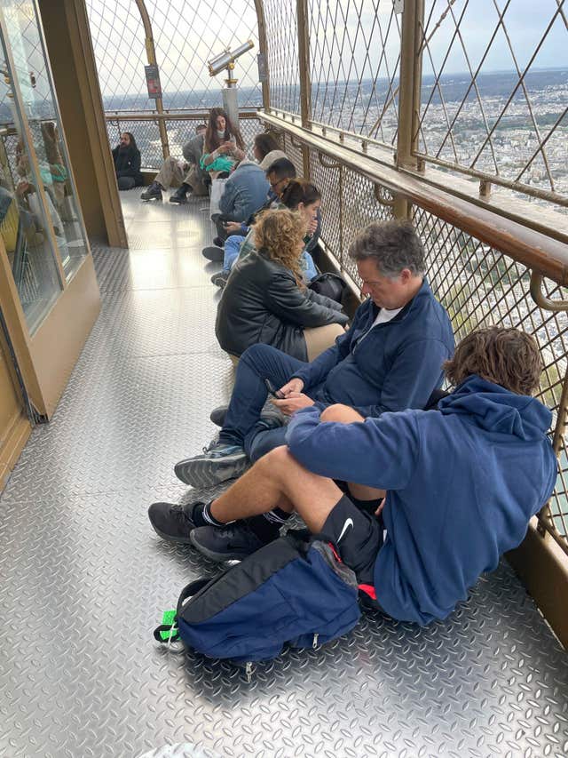 e4887f9047df46388b58ecbe263e0b04 Visitors stranded at the top of the Eiffel Tower while police and firefighters dealt with a man climbing on the structure wait for the lifts to reopen in Paris