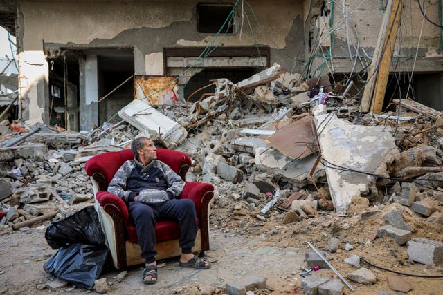 371652f0ce6e4284a3571b529026fc2a A Palestinian man sits in an armchair outside a destroyed building in Gaza City on Wednesday