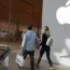 Couple walk past Apple store