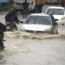 Vehicles drive on a flooded road in Mombasa, Kenya