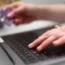 A woman using a laptop as she holds a bank card