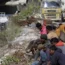 People sit near the site of the tunnel that has collapsed