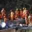 Rescuers rest at the site of the collapsed tunnel