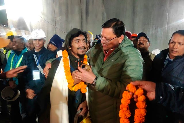 Pushkar Singh Dhami, right, chief minister of the state of Uttarakhand, greets a worker rescued from the site of an under-construction road tunnel that collapsed in Silkyara in the northern Indian state of Uttarakhand, India