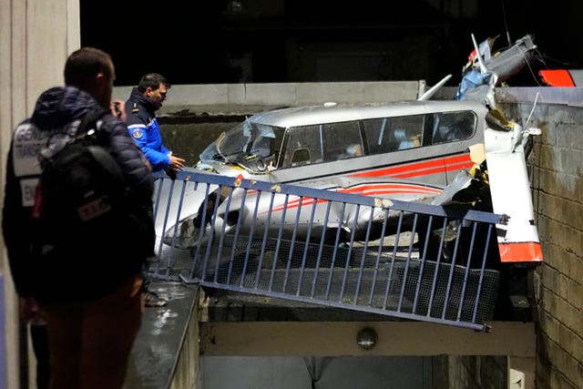 08c289222310478f9c9afaea40e142dc Police officers stand by a small plane that made an emergency landing in a residence in Villejuif, outside Paris