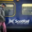 Passengers walking past a Scottish train