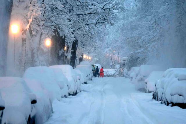 80279fe02c87416082c00fa97fa6db10 People remove a fallen tree from a road after heavy snowfall in Munich, Germany