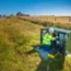 An engineer working on a traditional green street cabinet for broadband