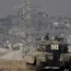 Israeli soldiers overlook the Gaza Strip from a tank, as seen from southern Israel