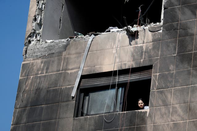 24e687e964e64ad69317d26abc334c13 A girl looks out from a window of a residential building after a reported Israeli attack on Syria (Omar Sanadiki/AP)