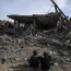 Palestinians inspect the damage after an Israeli raid on Rafah