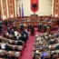 Members of the Democratic Party (left) look on as lawmakers of the ruling Socialist party vote in the Albanian Parliament