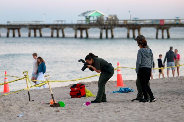 d08f0a55c4314eb5a1868d53784fb059 Investigators on the Florida beach