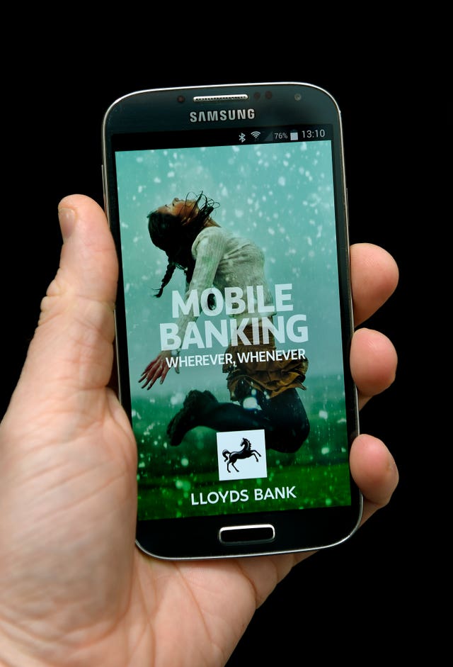 2-22453655 A hand holds a mobile device showing the Lloyds Bank app