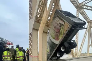 US driver rescued after crash leaves lorry dangling over side of bridge