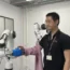 Dr Jihong Zhu testing out a robot dresser (University of York/PA)