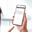 Woman holding a smart phone and using a chat bot app to ask questions about a smart watch. Showcases the use of AI language models to provide accessib