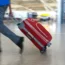 An airline passenger pulling a suitcase