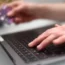 A woman using a laptop as she holds a bank card