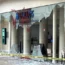 The windows of a branch of Barclays in Bristol are completely smashed, with red paint visible on the bank sign