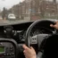 A female driver holding a car's steering wheel