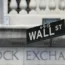A sign saying Wall St in front of the New York Stock Exchange