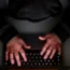 A laptop user with their hood up