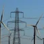 Wind turbines in front of electricity pylon and power lines