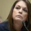 Head shot of a woman speaking into a microphone