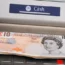 A cash machine dispensing £10 notes
